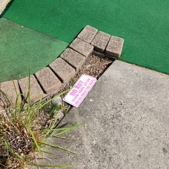 Golf Adventure - Fallen sign next to some weeds - Mini Golf Near Me - Fairless Hills, Pennsylvania
