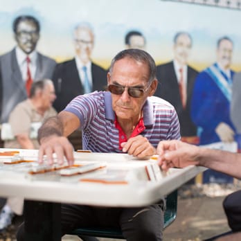 Maximo Gomez Park / Domino Park - Cool dude plays dominos in front of mural at Domino Park - Parks Near Me - Miami, Florida Maximo Gomez Park / Domino Park - Cool dude plays dominos in front of mural at Domino Park - Parks Near Me - Miami, Florida