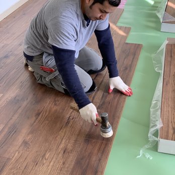 In Time Flooring - a man painting a wood floor - Flooring Near Me In Time Flooring - a man painting a wood floor - Flooring Near Me