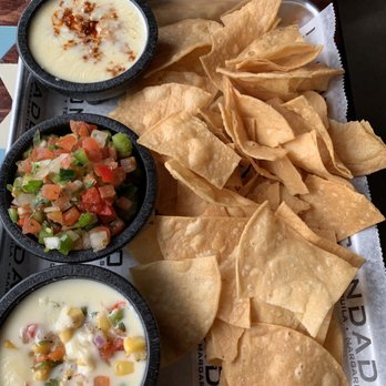 Condado Tacos - Chips with the half portions of from top to bottom  Queso with chorizo Mark's fav  Pico guaco so good  And corn salsa queso. My fav. - Tacos Near Me - Cincinnati, Ohio