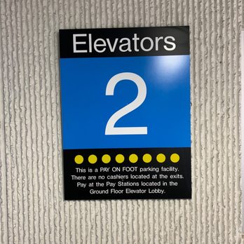 P Self Park - A sign for elevators 2 in a parking garage, with instructions for pay-on-foot parking and pay stations. - Parking Near Me