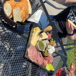 Charcuterie board with large side of bread.  3 cheeses, liver pate, salami, prosciutto, olives, pickles, apples.
