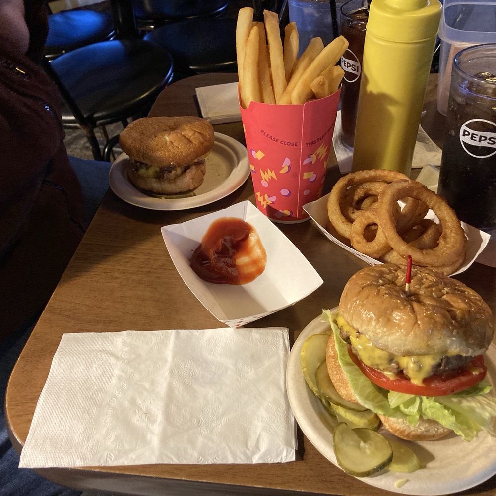 Two Talley burgers with sides of fries and onion rings Two Talley burgers with sides of fries and onion rings