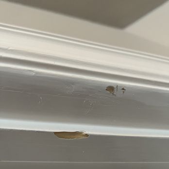Apache Moving & Storage - A close-up image of a white painted surface, possibly furniture or trim, showing chipped paint and minor damage. - Movers Near Me - Leander, Texas