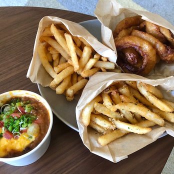 A+ Burger - Clockwise from left: Chili cheese for the chili cheese fries, regular fries, onion rings, garlic fries. Crispy and flavorful. - Burgers Near Me - Oakland, California