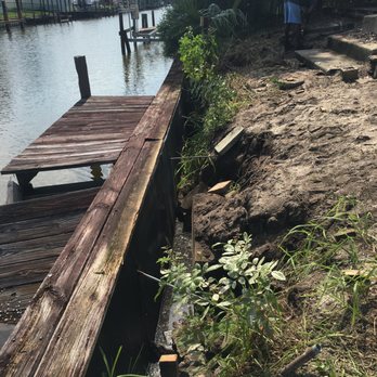 Premier Environmental Solutions - a man standing on a dock next to a body of water - General Contractors Near Me
