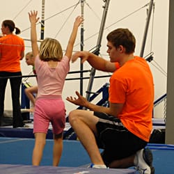 Champaign Gymnastics Academy - Coach Luke spots stations during the Beginner Girls class.