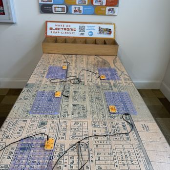 Wabash County Museum - Interactive learning center - A table features a printed city map surface with multiple electronic snap circuit components connected by wires, and a wooden storage box in the background. - Museums Near Me - Wabash, Indiana