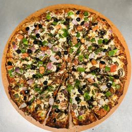 Curry Veggie Delight - A vegetable pizza featuring toppings such as green peppers, onions, mushrooms, and black olives, with melted cheese and a crispy crust. The pizza is sliced into eight pieces and presented on a wooden pizza peel, placed on a metallic surface.