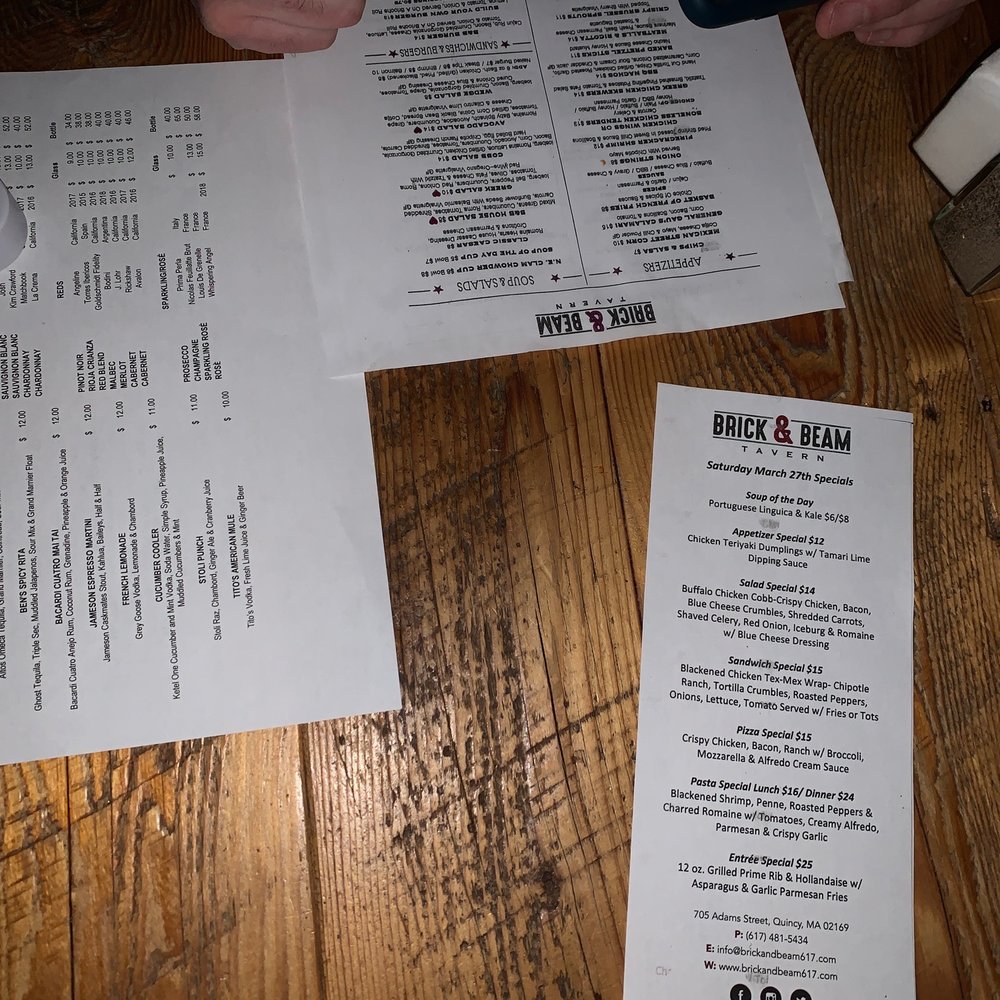 Brick & Beam - a person sitting at a table with a menu - Bars Near Me - Quincy, Massachusetts Brick & Beam - a person sitting at a table with a menu - Bars Near Me - Quincy, Massachusetts