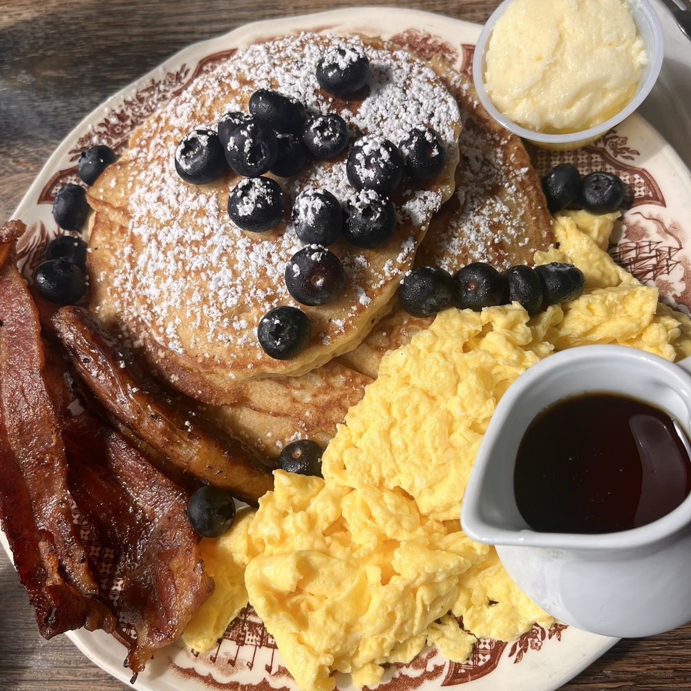 3 Blueberry topped pancakes, with eggs, sausage and bacon. This could easily be shared but this was the serving for one person. 3 Blueberry topped pancakes, with eggs, sausage and bacon. This could easily be shared but this was the serving for one person.