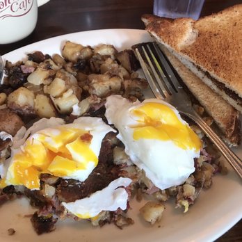 Union Cafe - Hash and poached eggs. GF toast. Hole fries - A breakfast dish featuring hash with poached eggs, toasted bread, and fried potatoes, served on a white plate at a cafe. - Diners Near Me - Schenectady, New York