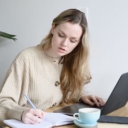 ExtraCredit - Online Math Tutoring - A student taking notes and studying with her tutor online.