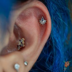 Rose Body Piercing - Helix piercing with a white gold and tanzanite borderline kite from Bvla.
