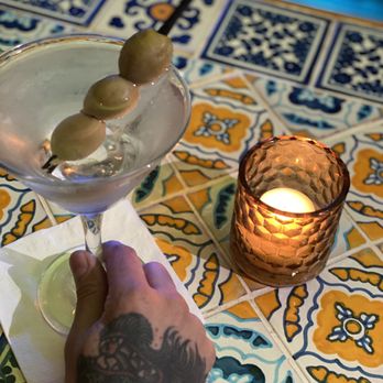 Burrito Loco - a hand holding a martini glass with olives - Mexican Near Me - New York, New York Burrito Loco - a hand holding a martini glass with olives - Mexican Near Me - New York, New York