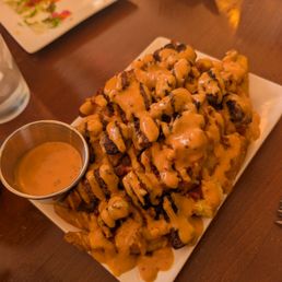 Fries steak bites bacon and a chipotle drizzle. Fries steak bites bacon and a chipotle drizzle.