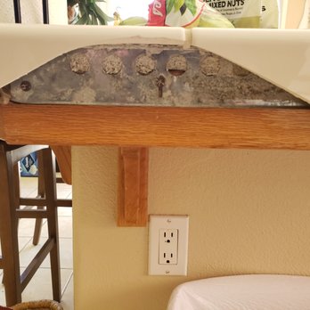 Trinity Remodel - Before - two broken tiles on the side of our kitchen island. - Flooring Near Me