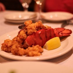 JK's Restaurant - A succulent lobster tail is generously crowned with crispy fried seafood, paired with a fresh lemon wedge and a side of dippi...