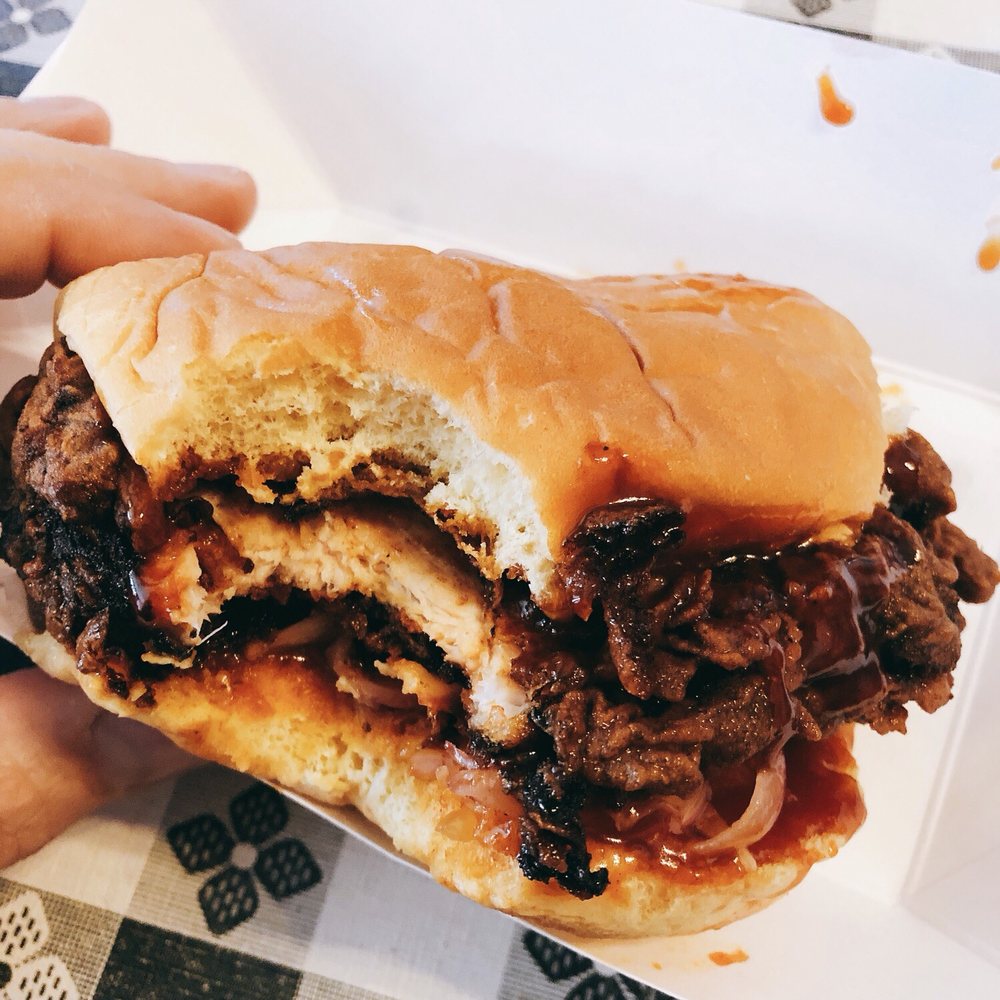 a hand holding a pulled pork sandwich a hand holding a pulled pork sandwich