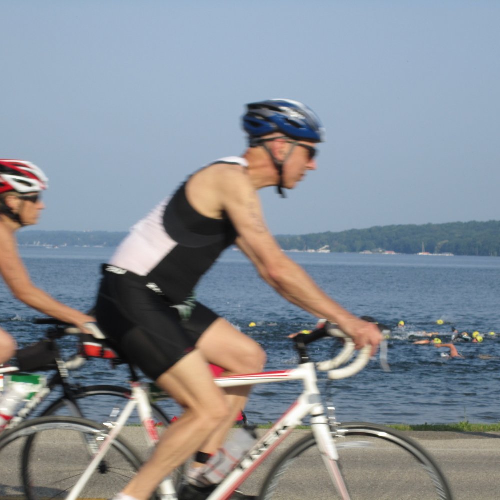 Bigfoot Triathlon - You can see swimmers in the lake and bikers riding beside them. - Races & Competitions Near Me - Lake Geneva, Wisconsin Bigfoot Triathlon - You can see swimmers in the lake and bikers riding beside them. - Races & Competitions Near Me - Lake Geneva, Wisconsin