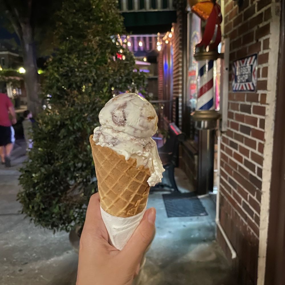 a hand holding an ice cream cone