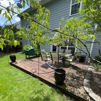 Maendel Construction - Wooden deck with patio furniture, surrounded by greenery and potted plants. - Fences & Gates Near Me Maendel Construction - Wooden deck with patio furniture, surrounded by greenery and potted plants. - Fences & Gates Near Me