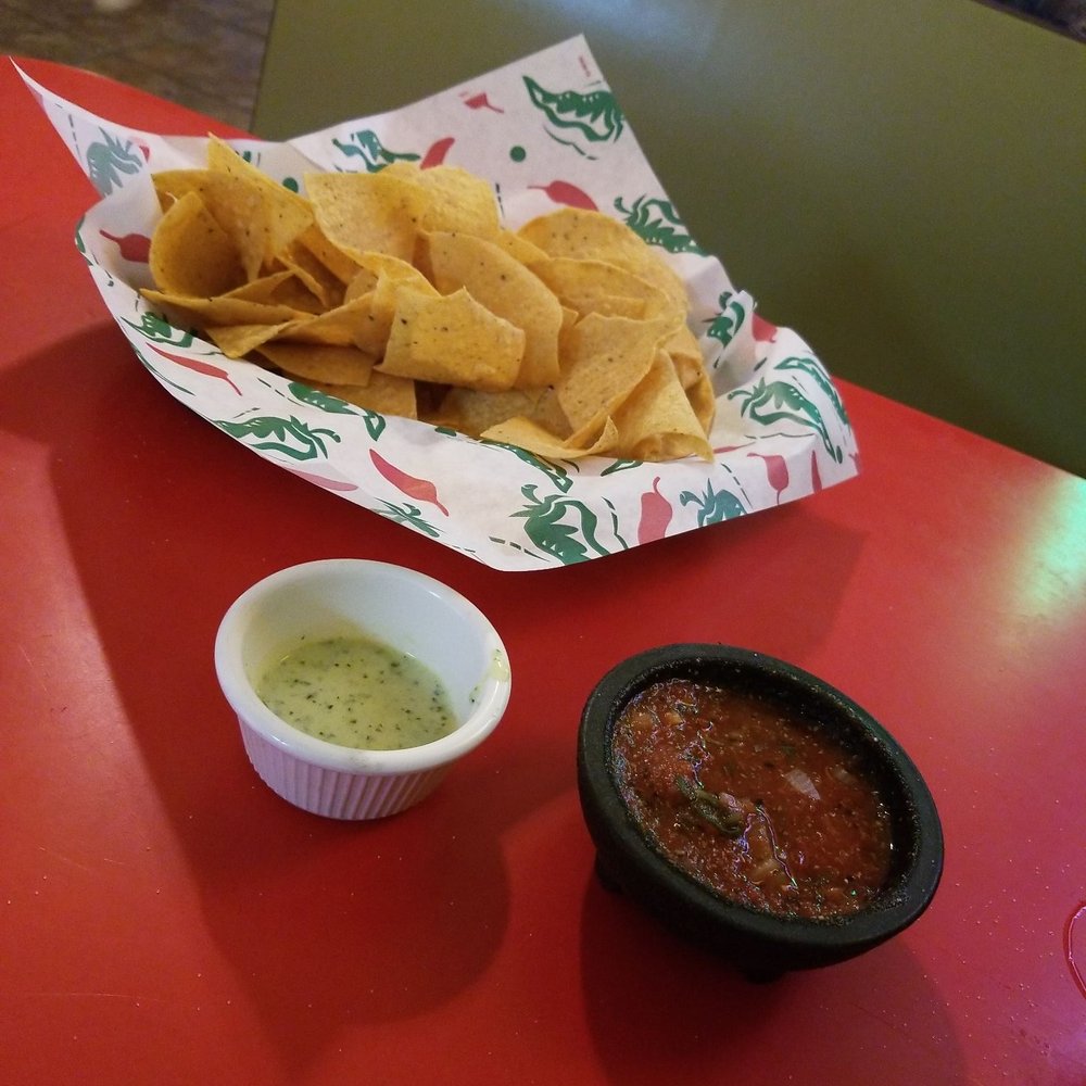 Chips, warm salsa, and delicious green sauce