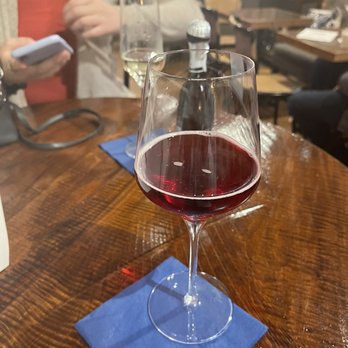 Wicked Dame - a glass of wine on a table - Wine Bars Near Me - Dubuque, Iowa