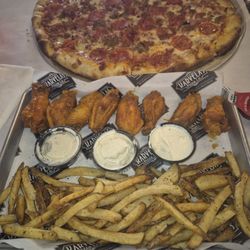 Karvelas Pizza - 8 wings with fries and a cave man pizza