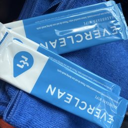 Two blue disposable wipes labeled 'EVERCLEAN' rest on a blue towel or cloth, with a hint of orange fabric visible underneath.