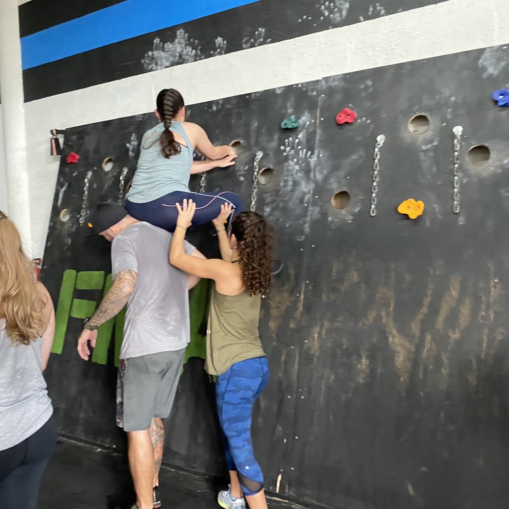 Focused Movement Academy - New member being assisted across obstacle - Boot Camps Near Me - Miami, Florida Focused Movement Academy - New member being assisted across obstacle - Boot Camps Near Me - Miami, Florida