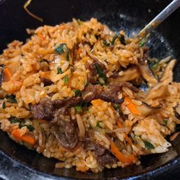 Beef Bibimbap stirred up with bibimbap sauce and partially eaten Beef Bibimbap stirred up with bibimbap sauce and partially eaten