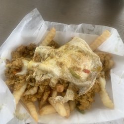 Salmon covered fries with egg.