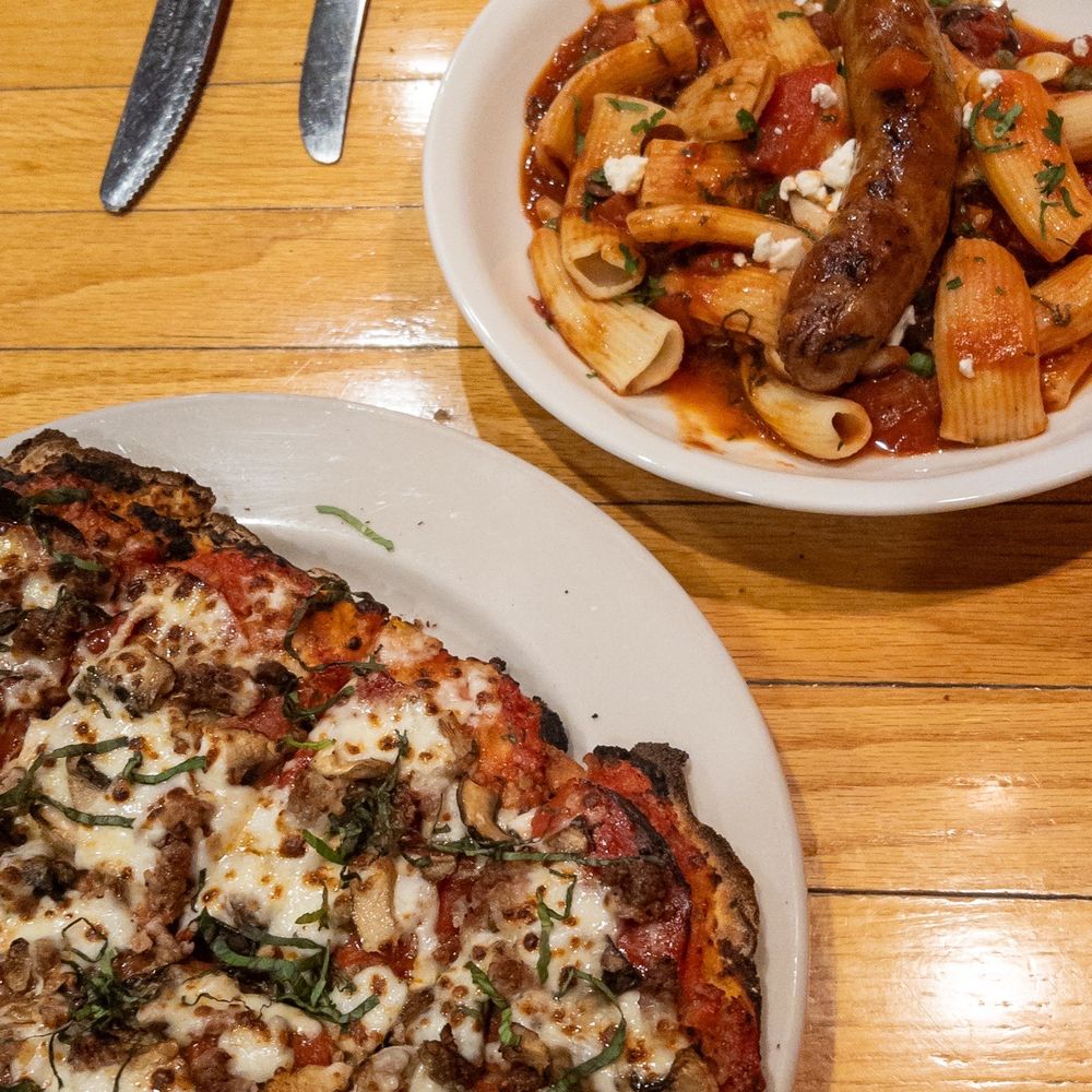 Mona Lisa's - Mother T and Me Pinsa (no olives, basil added) and Puttanesca with Sausage. - Italian Near Me - Eau Claire, Wisconsin Mona Lisa's - Mother T and Me Pinsa (no olives, basil added) and Puttanesca with Sausage. - Italian Near Me - Eau Claire, Wisconsin
