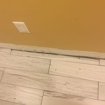 New Image Floors - a tile floor with a hole in the middle - Flooring Near Me