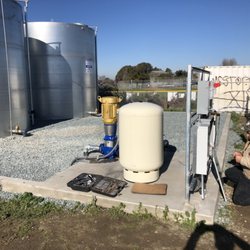 Multiple Storage Tank Installation with booster pump, pressure tank, and VFD well pump/motor.