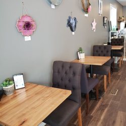Elpida Cafe And Roastery - Inside the cafe
Artwork made by local artists is displayed on one wall of the cafe, to showcase and sell, with a new artist each month