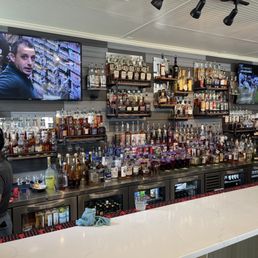 a bar with a large screen tv a bar with a large screen tv