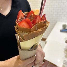 a woman holding a paper bag with strawberries and strawberries in it a woman holding a paper bag with strawberries and strawberries in it