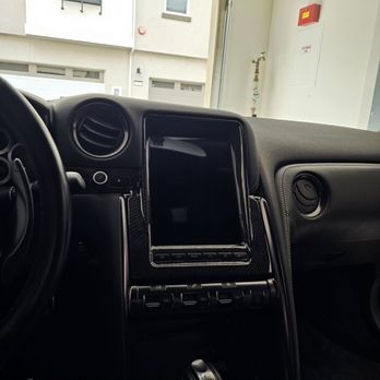 North County Mobile Electronics - Nifty City Tesla style screen (Android) - The photo shows the dashboard of a vehicle with a large central touchscreen, climate control buttons, and air vents, taken from the driver's side. - Car Stereo Installation Near Me - Oceanside, California