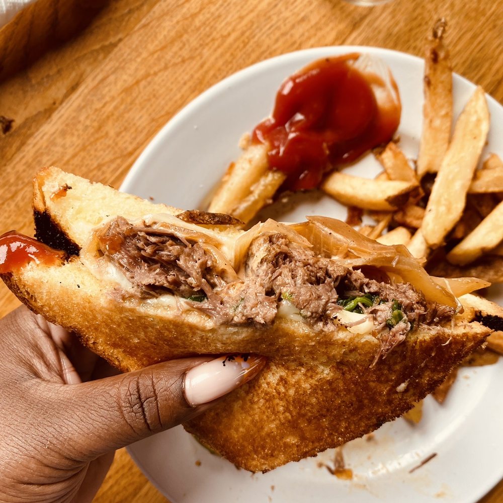 Miles Table - a person holding a sandwich and french fries - American Near Me - Philadelphia, Pennsylvania Miles Table - a person holding a sandwich and french fries - American Near Me - Philadelphia, Pennsylvania