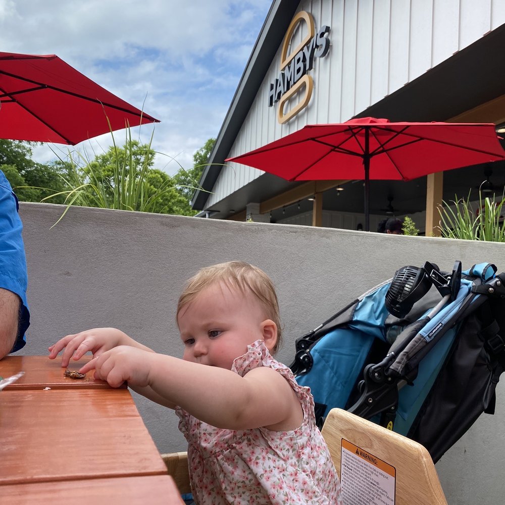 Hamby's - Baby feeding herself burger. - Brewpubs Near Me - Boerne, Texas