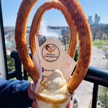 Hola Churros - a hand holding a cup of ice cream - Desserts Near Me - Niagara Falls, Ontario
