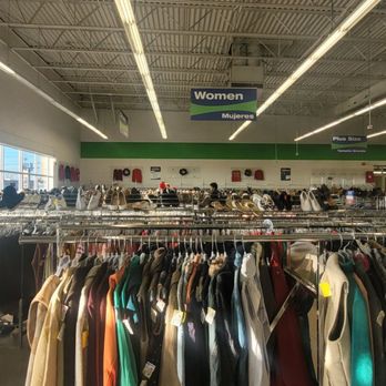 Goodwill - Inside a Goodwill store in Reading, PA, clothing racks filled with various garments are visible, with signage indicating sections for women. Large windows on the left allow natural light to illuminate the space, and overhead lighting enhances visibility. The store has a spacious layout with a high ceiling and organized displays. - Community Service/Non-Profit Near Me - Reading, Pennsylvania
