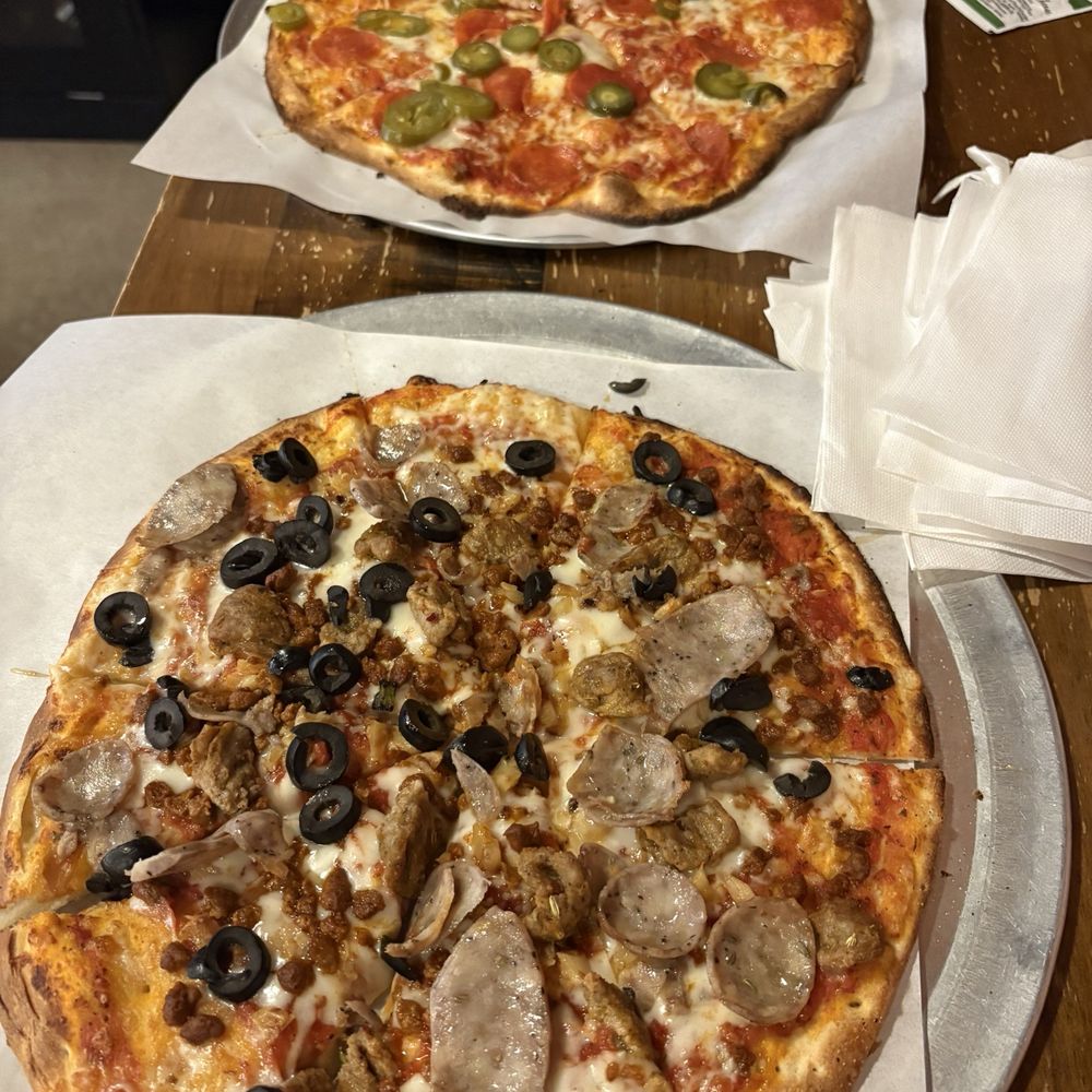 Pepperoni Pizza w/ Jalapeños (back), Sausage Lovers Pizza w/ Roasted Garlic and Black Olives (front)