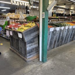 a man standing in front of a fruit stand a man standing in front of a fruit stand