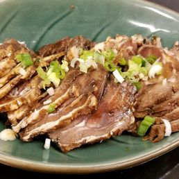 a plate of sliced meat on a table