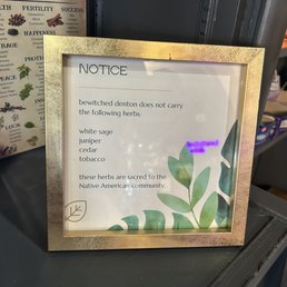 Herbs they don't carry - A framed notice at Bewitched Denton in Denton, TX, states the store does not carry certain herbs, including white sage, juniper, cedar, and tobacco.