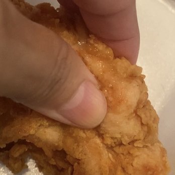 Raising Cane's Chicken Fingers - Squeezing the soft breading, you can see the oil near my fingers. - Fast Food Near Me - Avondale, Arizona