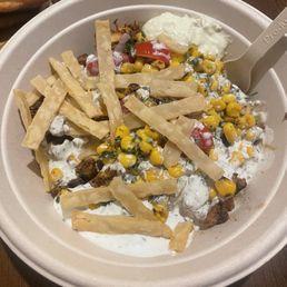 a bowl of mexican food with tortilla and corn